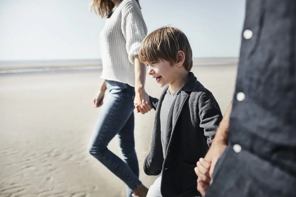 Family walking hand in hand on the beach.